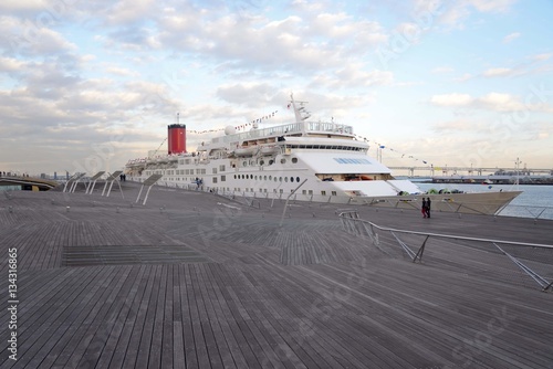 大桟橋のデッキとベイブリッジを背景に停泊する白い客船
ベイブリッジを背景に停泊する客船の赤い煙突が印象的だ。