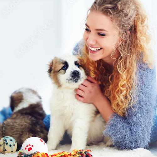beautiful woman playing with cute caucasian shepherd puppies
