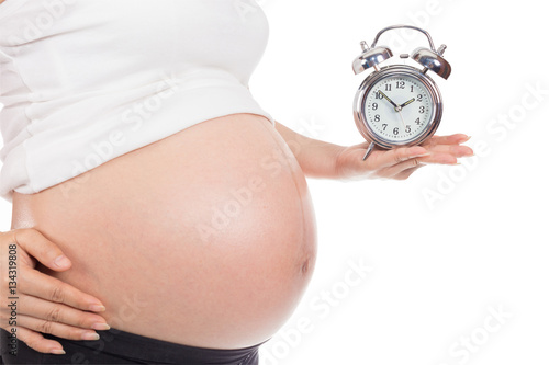 Pregnant woman holding clock.