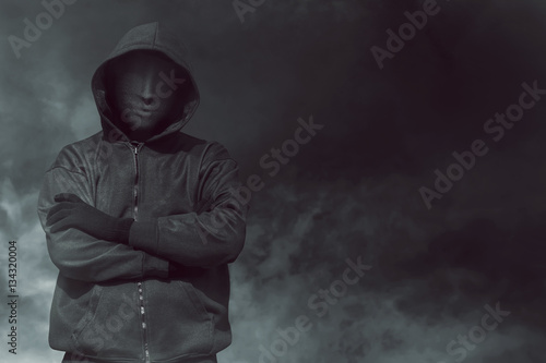 Hooded man with mask standing alone photo