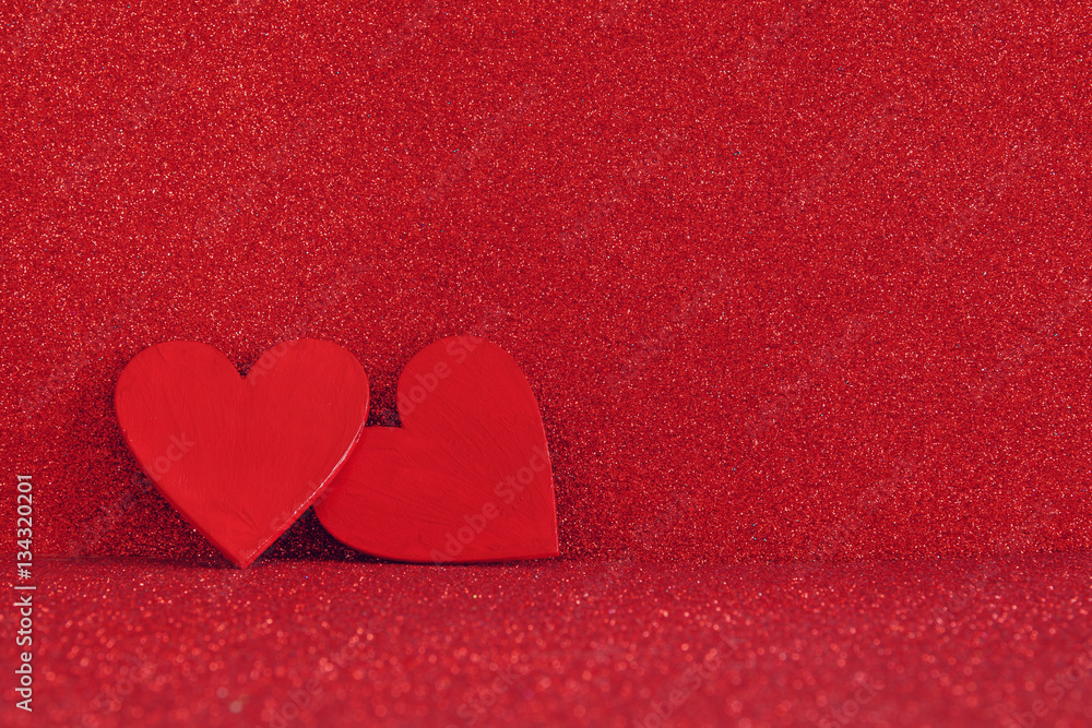 Fototapeta premium Wooden red hearts on red shiny background