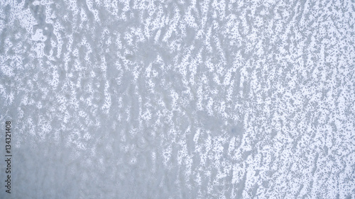 Texture of ice surface. Aerial view of frozen river from above with snow ornament