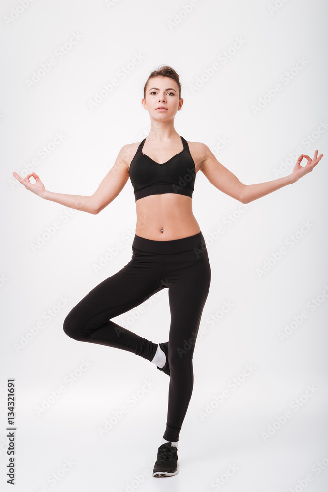 Concentrated young fitness woman make yoga exercises Concentrated young fitness woman make yoga exercises