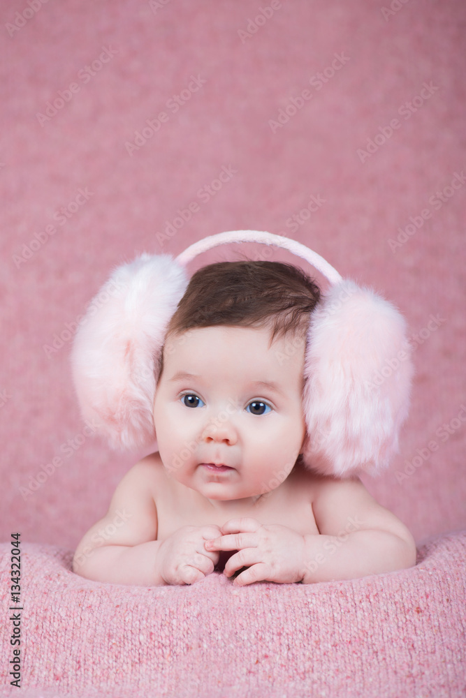 Beautiful little girl in pink warm headphones Beautiful little girl in pink warm headphones