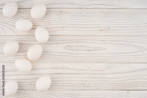 Chicken eggs on white old wooden table.