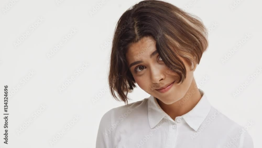 Young beautiful brunette east asian female in shirt looking childish shy coy on white background Young beautiful brunette east asian female in shirt looking childish shy coy on white background