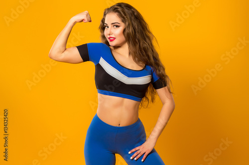 beautiful athletic girl shows muscles