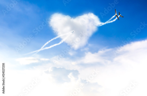 Love is in the two bird flying blue sky with hearts shape clouds
