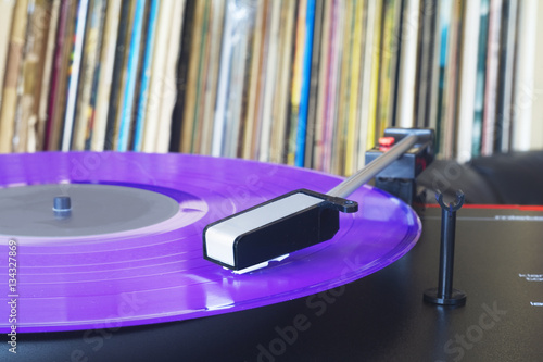 vintage turntable with vinyl record and record collection photo