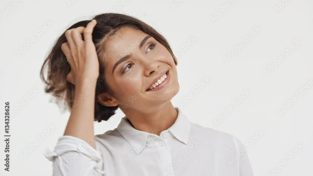 Young beautiful brunette east asian female in shirt looking up smiling in astonishment on white backgroundin slowmotion Young beautiful brunette east asian female in shirt looking up smiling in astonishment on white backgroundin slowmotion