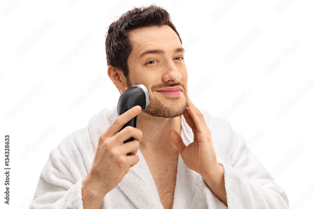 Handsome guy trimming his beard with an electric razor Handsome guy trimming his beard with an electric razor