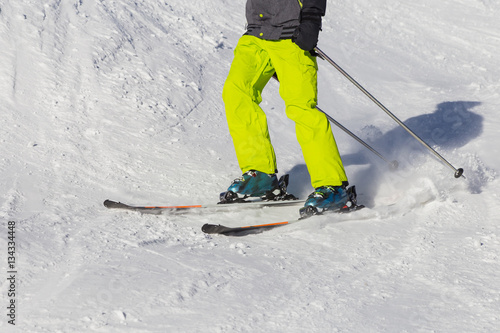 Ski, skier, sun and winter fun, skis, ski boots, mountains. Bright, colorful, colored clothing