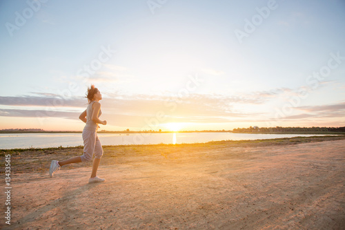 asian woman runing along the sea coast