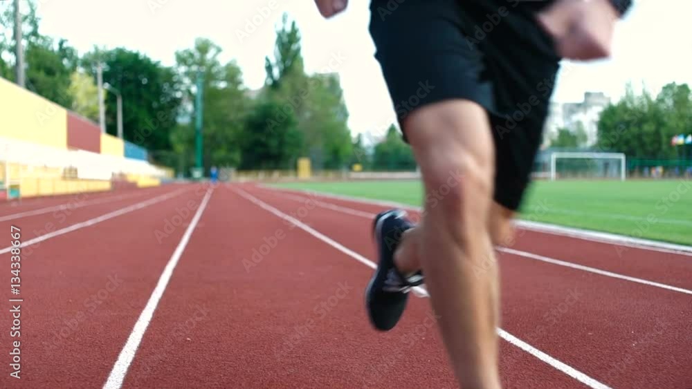 Young concentrated man on a racetrack preparing to run at stadium Young concentrated man on a racetrack preparing to run at stadium