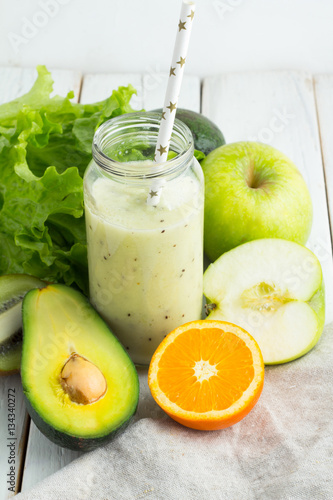 Green smoothies fruit and vegetables on a wooden background
