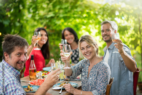 Group of friends toasting during a party on a terrace in summer