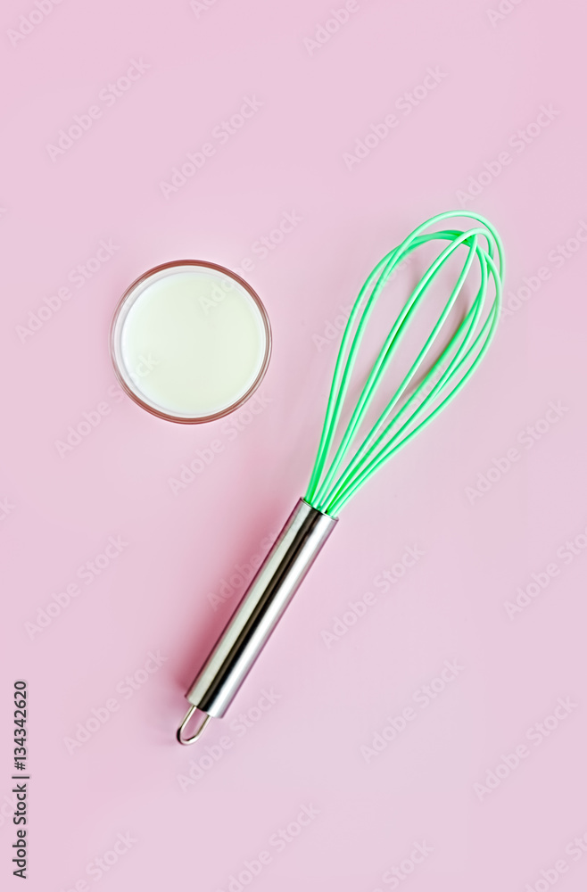 Minimal concept. Colorful creative flat lay, neon greenery silicon whisk and glass of milk on a pink background. Minimal concept. Colorful creative flat lay, neon greenery silicon whisk and glass of milk on a pink background.