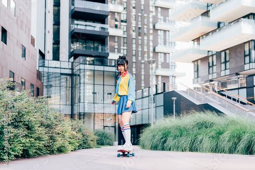 young beautiful asian millennial woman nonconformist skating outdoor in the city - skater, transport, eccentric concept