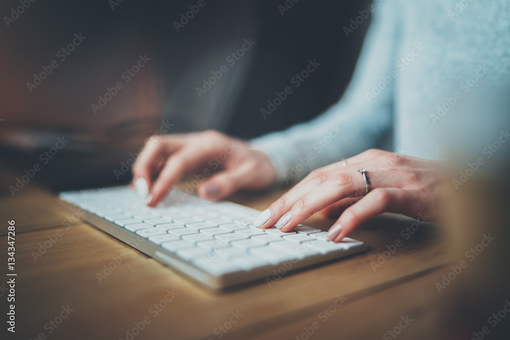 Female hands typing keyboard.Selective focus on hand.Blurred background.Horizontal. Female hands typing keyboard.Selective focus on hand.Blurred background.Horizontal.