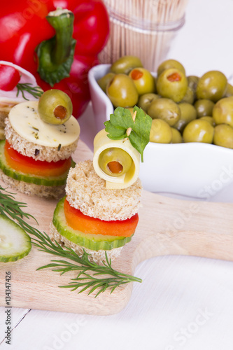 finger food with bread, peppers, cucumber, cheese and olives