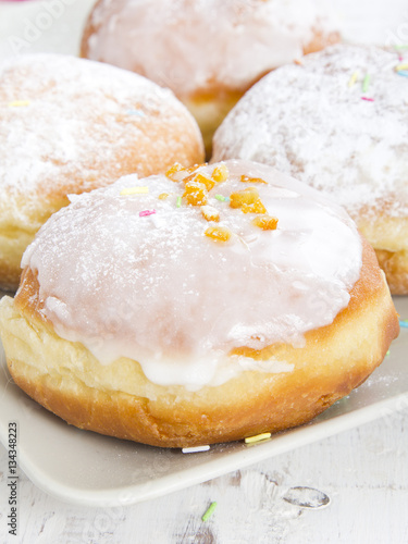 donuts with frosting and powdered sugar on a platter