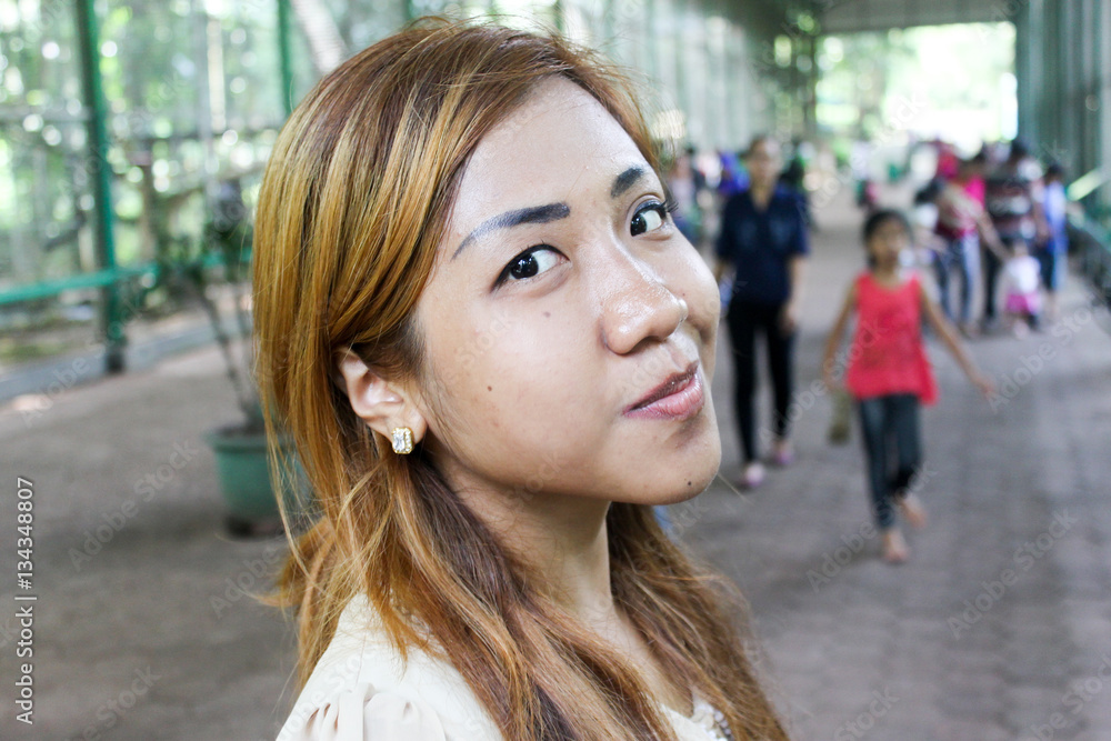 Asian girl posing on crowded with people street