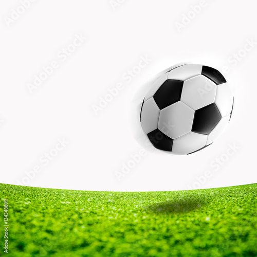 Flying soccer ball on green grass background.