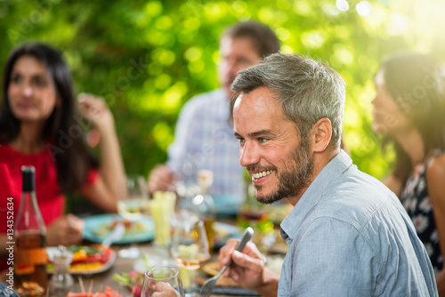 A man lunching with friends on a terrace table