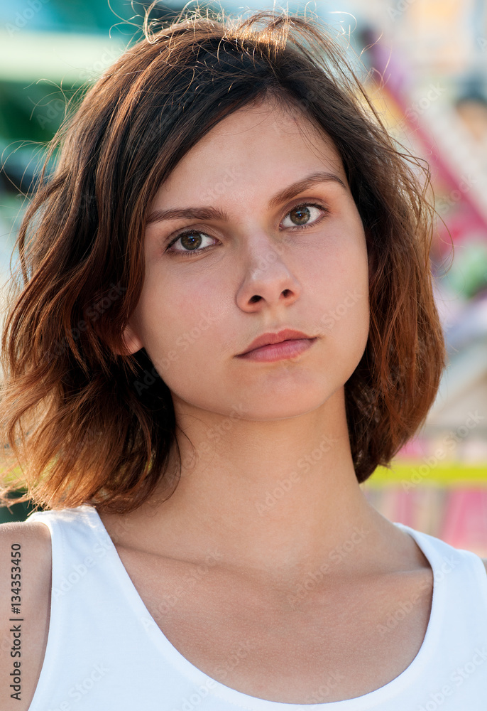 Close up portrait of teen brunette in white shirt in fun park Close up portrait of teen brunette in white shirt in fun park