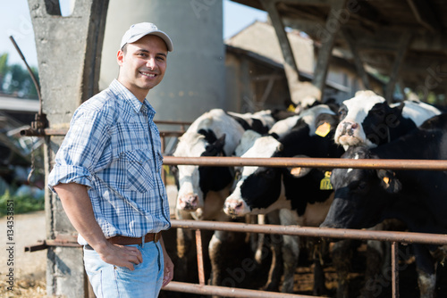 Fotografia, Obraz Breeder in front of his cows