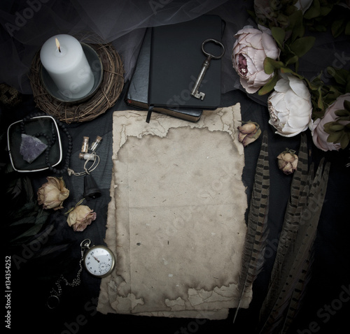Vintage table with paper, flowers, old watch and candle