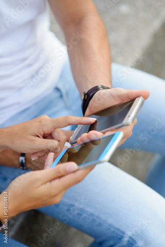 Close up of young couple using smartphones together. Modern relationship and technology use concept.