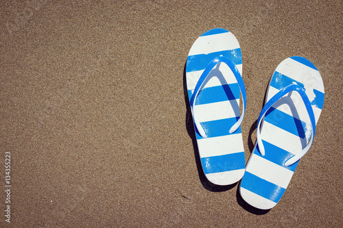 Flip flops on a sandy ocean beach