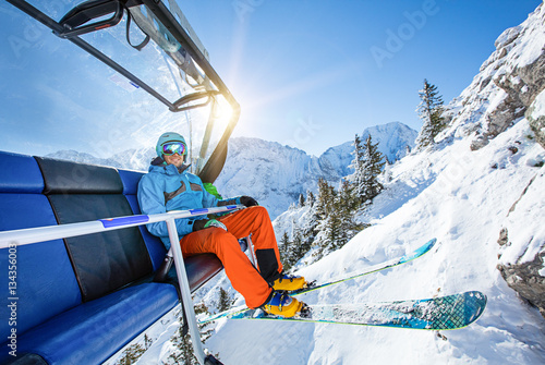 Skier sitting at ski lift.