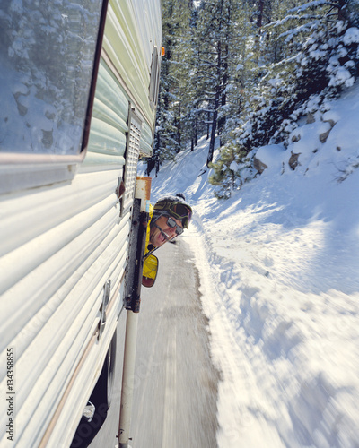 Man with head through camper van window, in motion 
