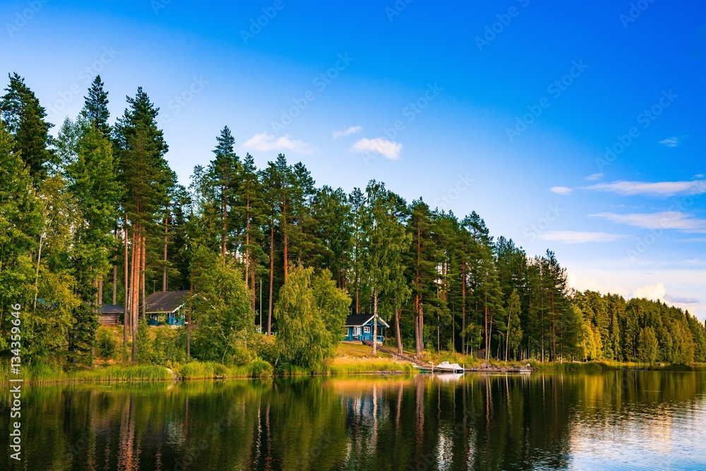 Obraz premium Blue wooden sauna log cabin on the lake in Finland