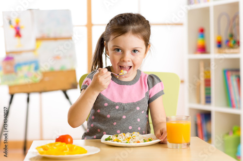 kid girl eating healthy foo...