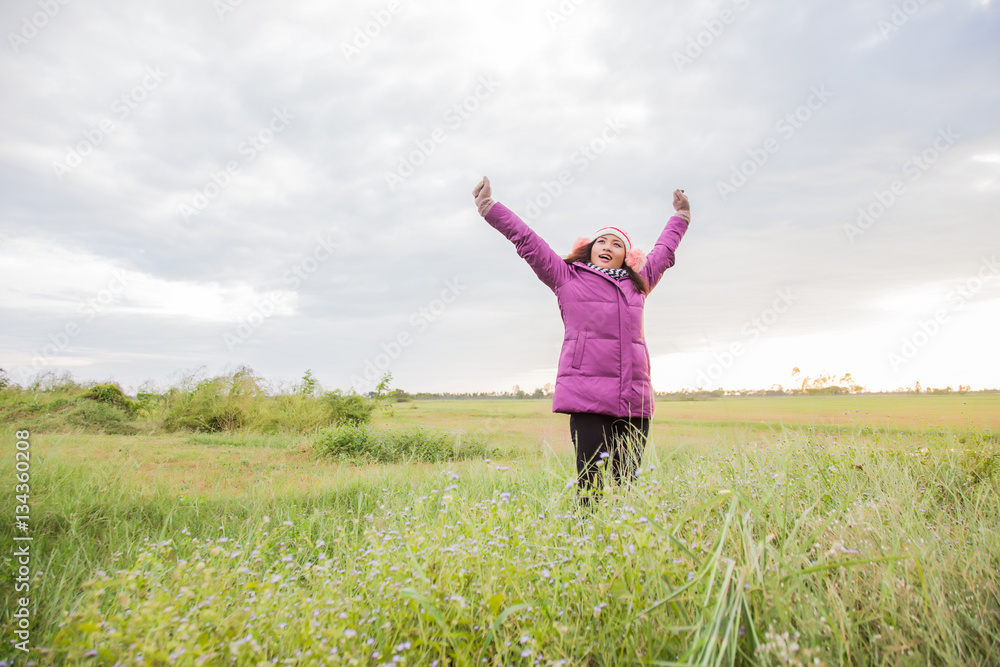 Young woman was playing in a field of flowers in the winter air. Young woman was playing in a field of flowers in the winter air.