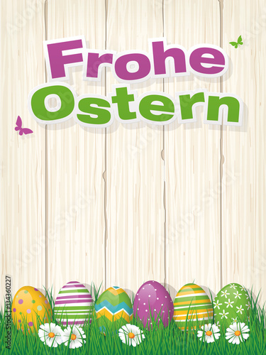 Frohe Ostern Grusskarte mit Ostereiern im Gras vor Holzwand