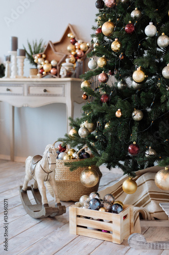 fir-tree with Christmas decorations in a white bedroom