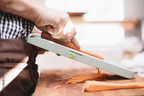 Chef's hands slicing carrots on mandoline photo
