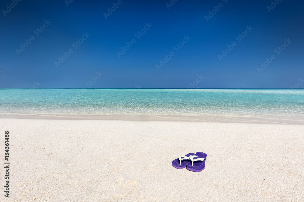 Flip-flops on sand on tropical beach in Maldives