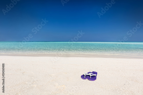 Flip-flops on sand on tropical beach in Maldives