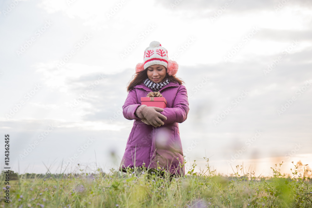 Happy young woman with gift in hands. Christmas and winter conce Happy young woman with gift in hands. Christmas and winter conce