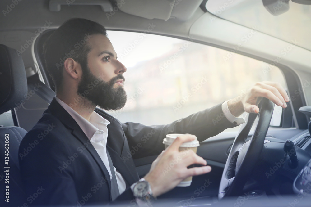 Man driving while holding his coffee