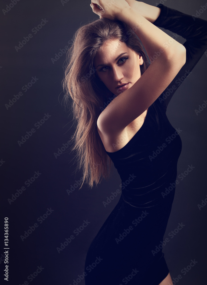 Sexy natural figure slim model posing in black dress on dark gre Sexy natural figure slim model posing in black dress on dark gre