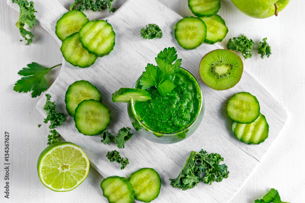 Fresh Green smoothie with kale, cucumber, lime, apple, parsley on white board. Fresh Green smoothie with kale, cucumber, lime, apple, parsley on white board.