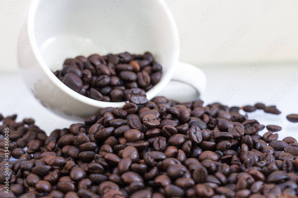 Coffee beans in coffee cup isolated on white Coffee beans in coffee cup isolated on white