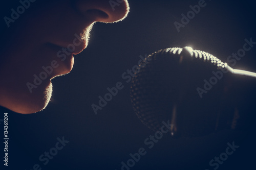 Obraz na plátně Woman singing to microphone