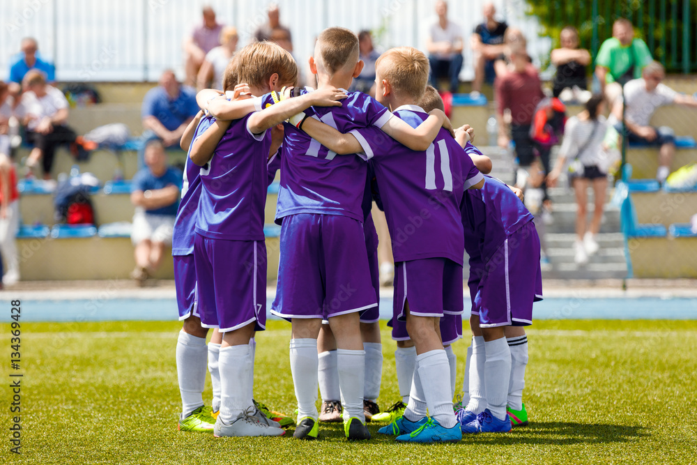 Children's Football Team on the Pitch. Boys in Purple Soccer Jersey Shirts  Standing Together on the Football Field. Motivated Young Soccer Players  Before the Final Game of School Tournament Stock Photo